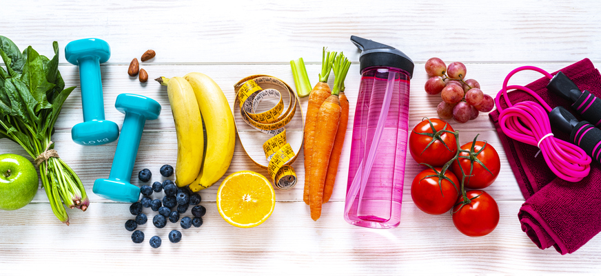 photo of fresh fruits, veggies, dumbbells, and water bottle to show healthy lifestyle choices