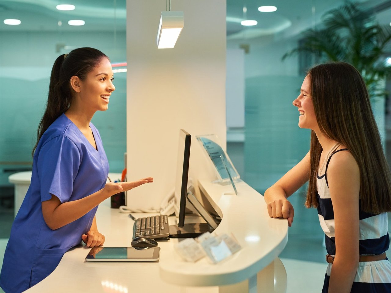 Healthcare staff at front desk verifying patient coverage