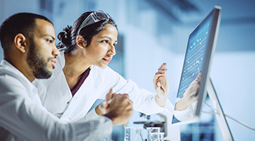 Doctor and lab tech looking at computer
